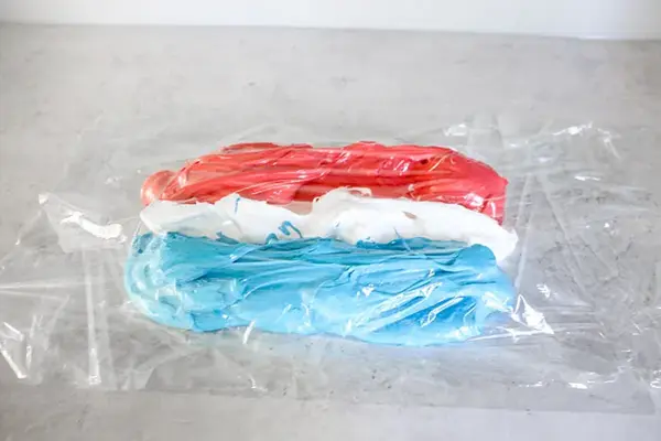 Tre rader marengs i blå, hvit og rød på kjøkkenbenk