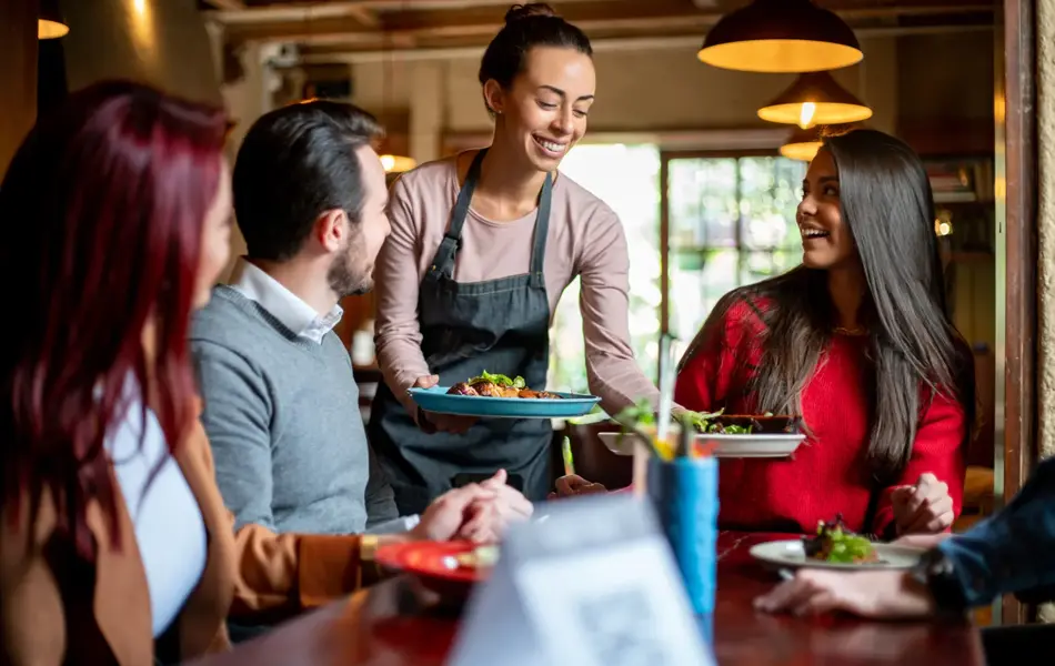 dame serverer kunder på spisested