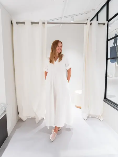 Damemodell med hvit lang kjole og hvite sko.