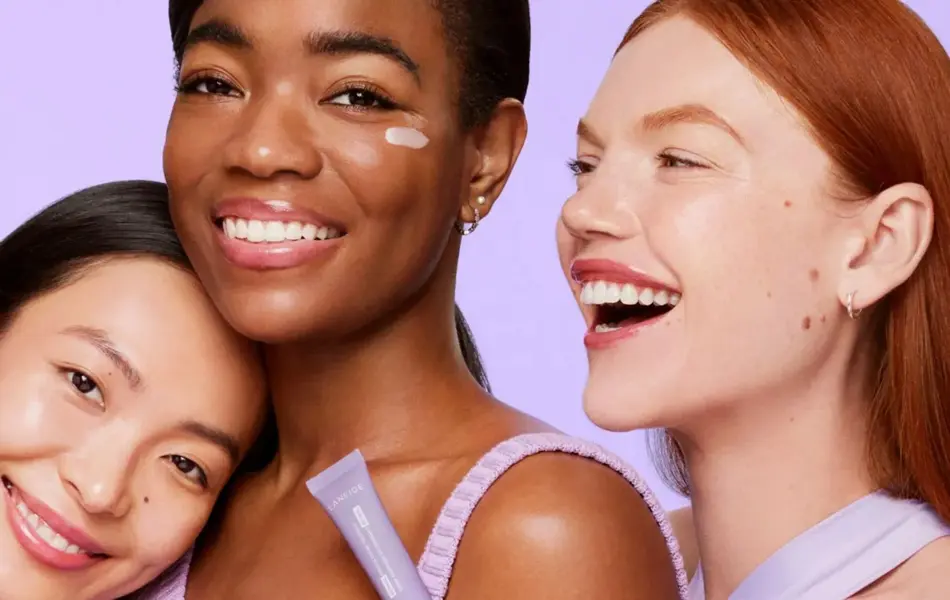 Tre damer som smiler med lillebakgrunn