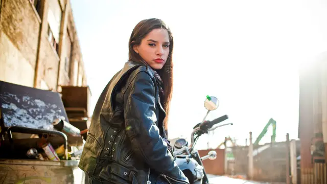 Dame i bikerjakke sittende på en motorsykkel 