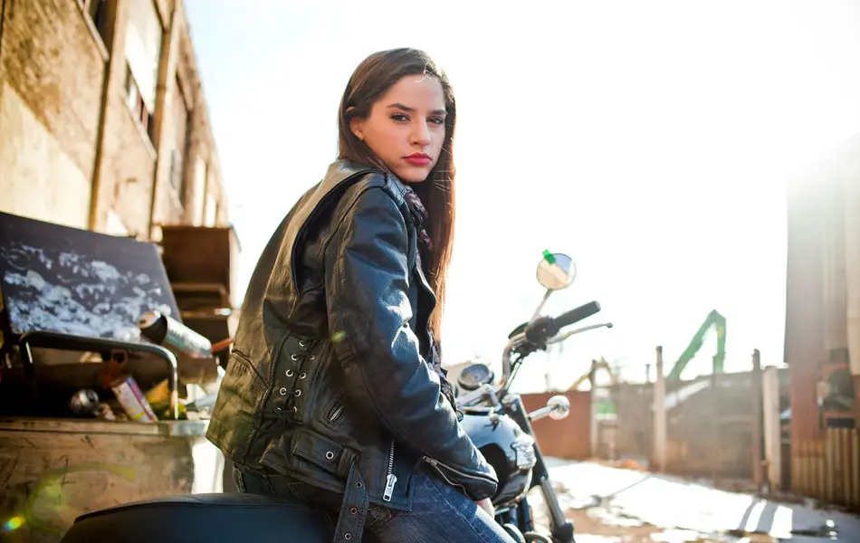 Dame i bikerjakke sittende på en motorsykkel 