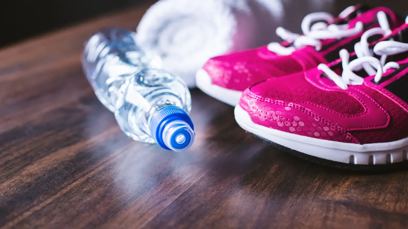 Nærbilde av vannflaske og treningssko