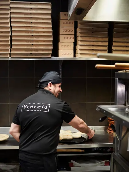 kokk som lager pizza hos grand caffe venezia