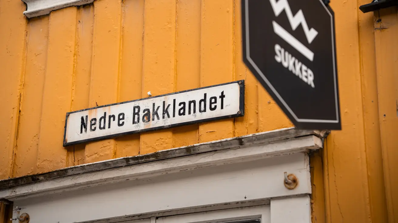 Gul husvegg med veiskilt på veggen