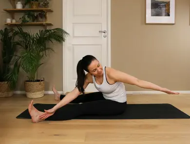 Anna viser Pilates-øvelser på treningsmatte på gulvet