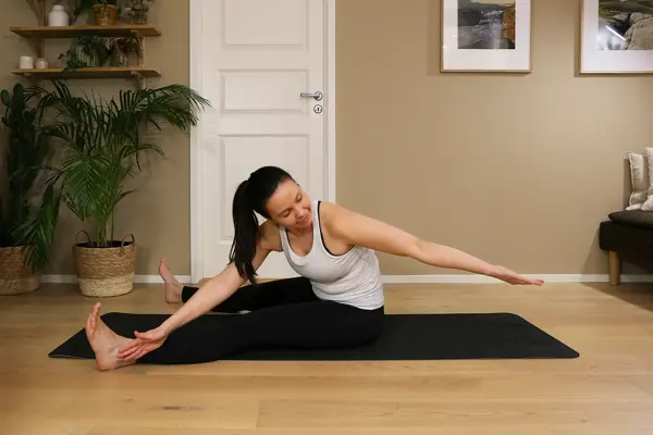 Anna viser Pilates-øvelser på treningsmatte på gulvet