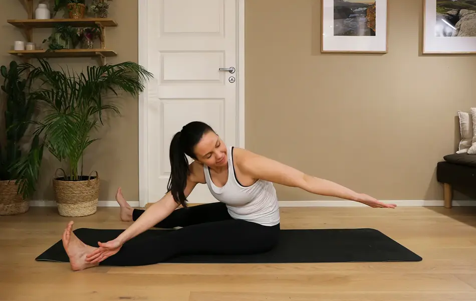 Anna viser Pilates-øvelser på treningsmatte på gulvet