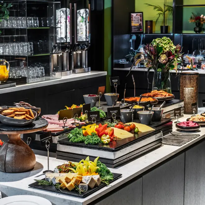 Diverse fargerikt pålegg satt frem på en frokostbuffet.