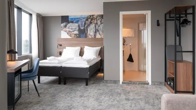 Business rom med dobbeltseng, teppegulv og åpen garderobe