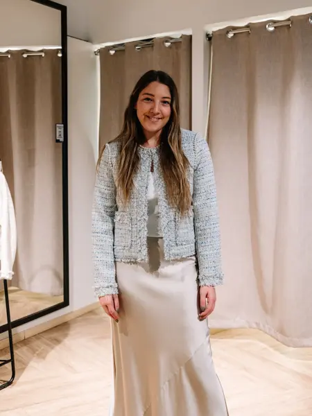 dame i vårklær står ved prøverom