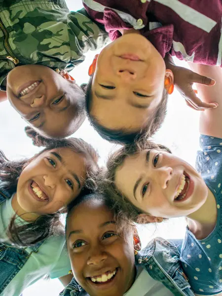 Barn som står sammen og smiler til kamera