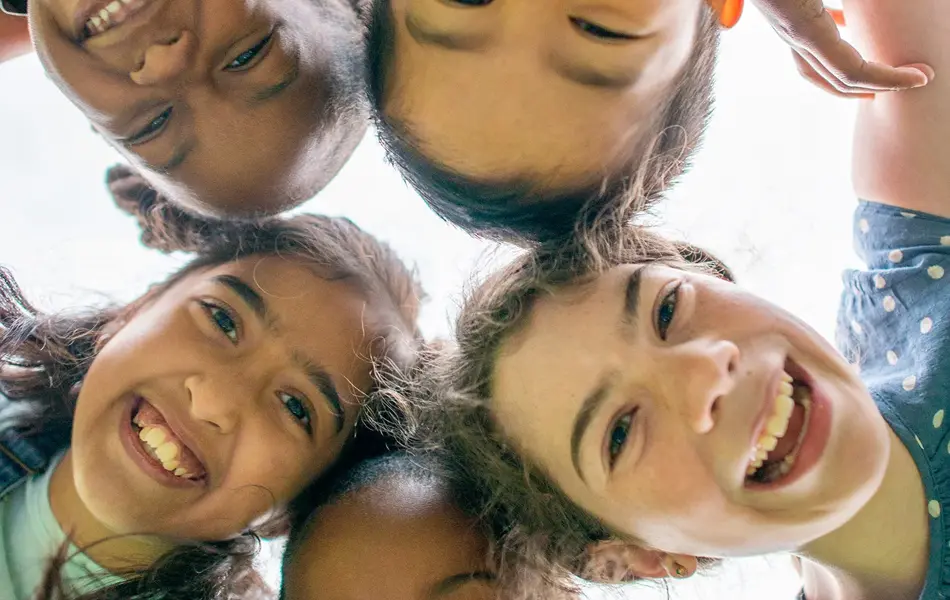 Barn som står sammen og smiler til kamera