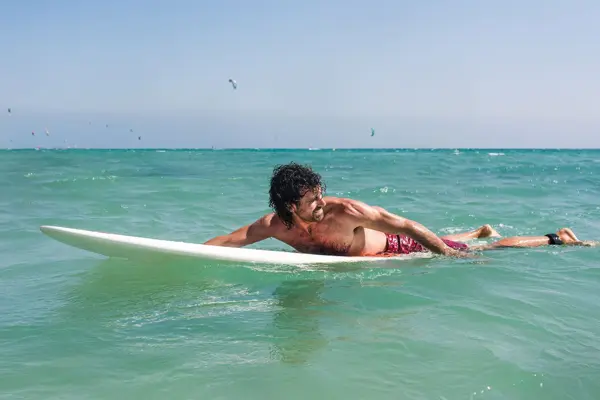 En mann som ligger på et stupebrett i havet.