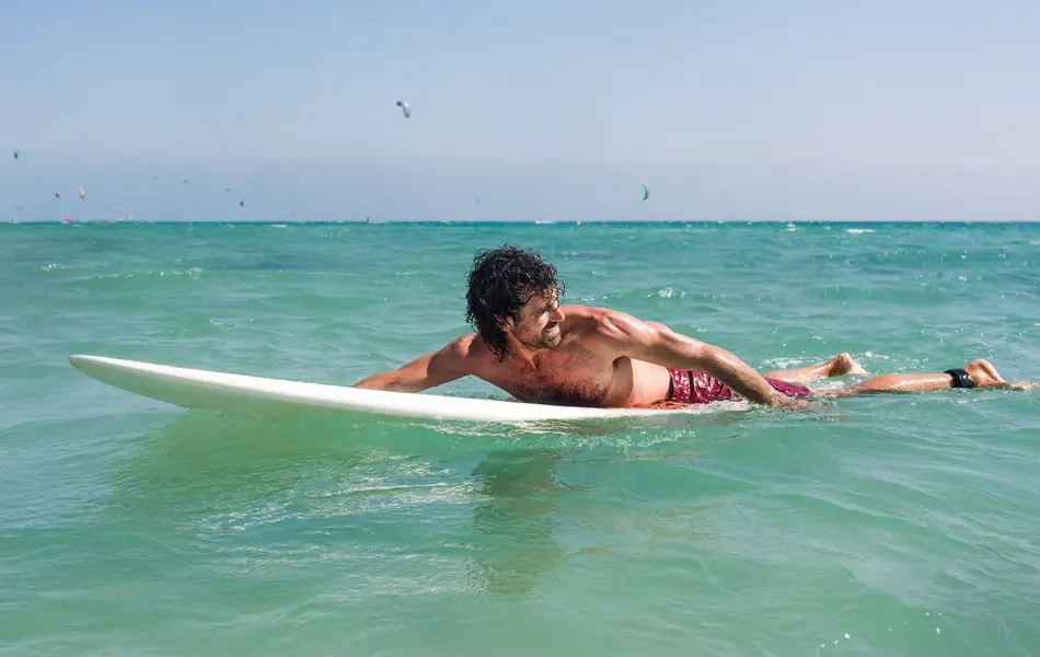 En mann som ligger på et stupebrett i havet.