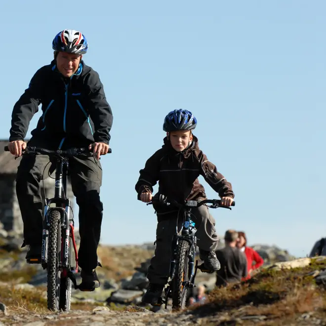 Far og sønn sykler i terreng på Skeikampen