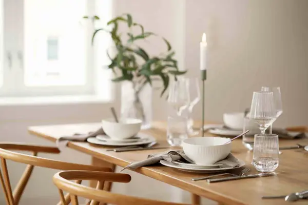 Dekket spisebord med stoler rundt.