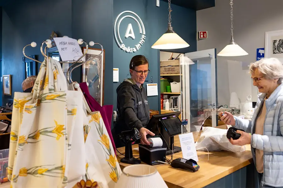 dame som betjener kunde i kasse i butikken