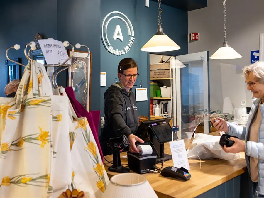 dame som betjener kunde i kasse i butikken