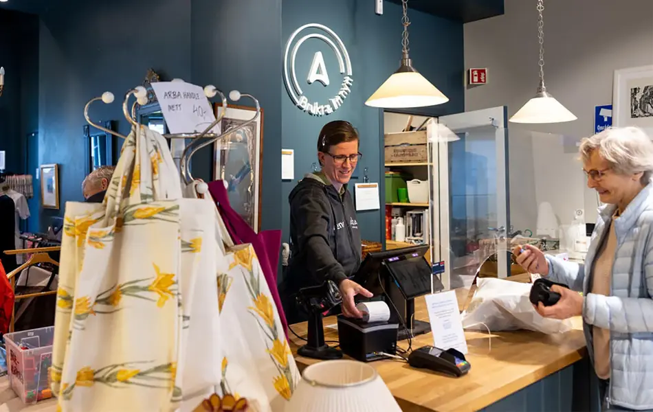 dame som betjener kunde i kasse i butikken