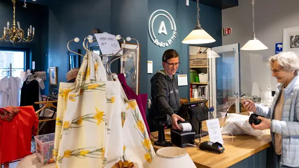 dame som betjener kunde i kasse i butikken