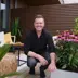 Espen Skarphagen sitter på en balkong omgitt av planter og utemøbler.