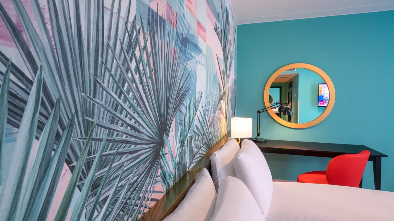 Fargerik palmetapet og dobbeltseng i superior rom på thon Hotel Storo