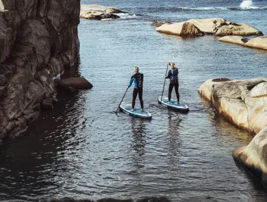 To personer på hvert sitt SUP-brett på vannet