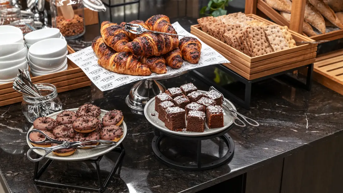 Nærbilde av frokostbuffet med diverse bakevarer og knekkebrød