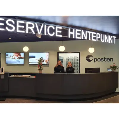 to damer står bak disken til kundeservice, hentepunkt og posten