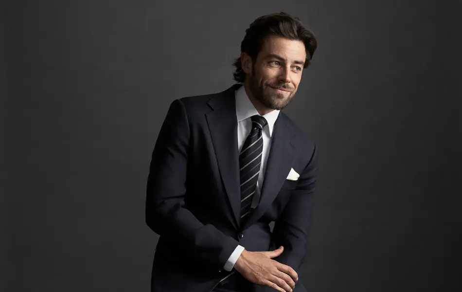 Mann i dress som sitter på en stol