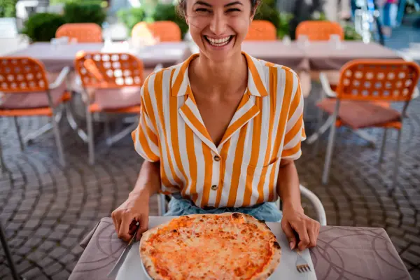 High angle view of a tourist woman eating pizza in Italy