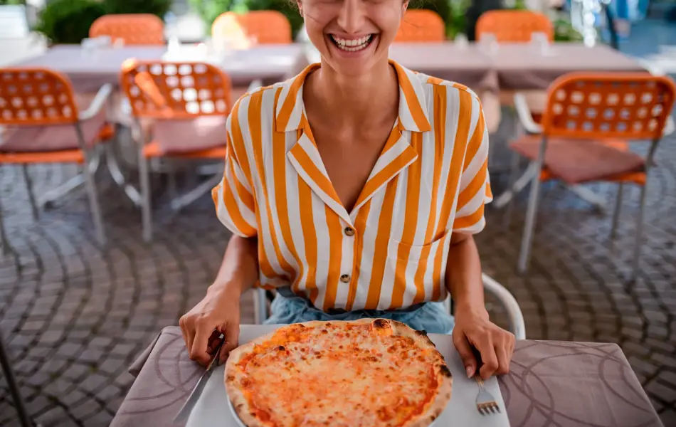 High angle view of a tourist woman eating pizza in Italy