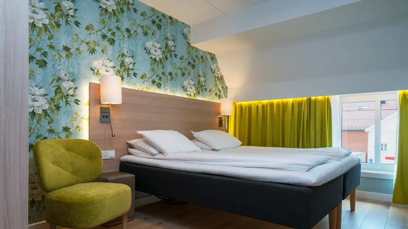 Seng og stol på soverom i suiten på Thon Hotel Tønsberg Brygge