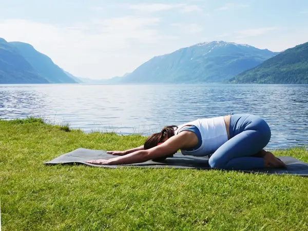 anny johansen viser yogaøvelser foran vakker fjord