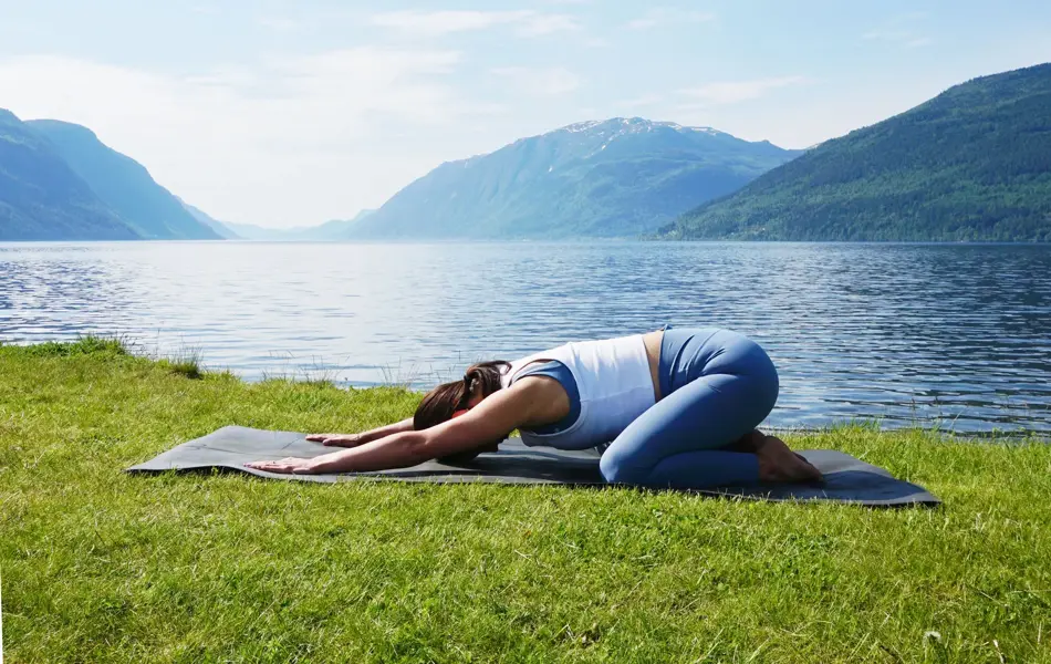 anny johansen viser yogaøvelser foran vakker fjord