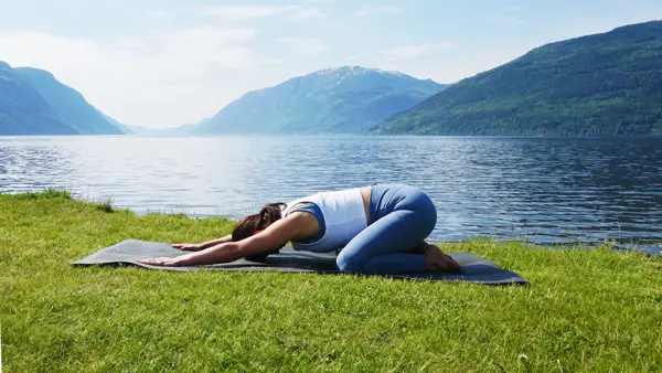 anny johansen viser yogaøvelser foran vakker fjord