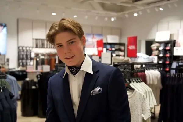 gutt i dress med skjerf i halsen