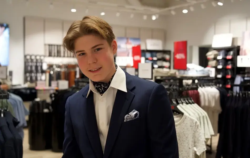 gutt i dress med skjerf i halsen