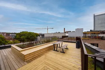 Felles takterrasse med tredekke, sitteplasser og utsikt over nærområdet.