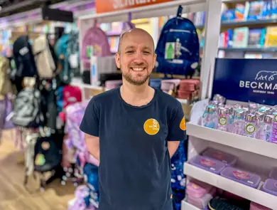 Ansatt fra Ark Bokhandel som smiler i butikken