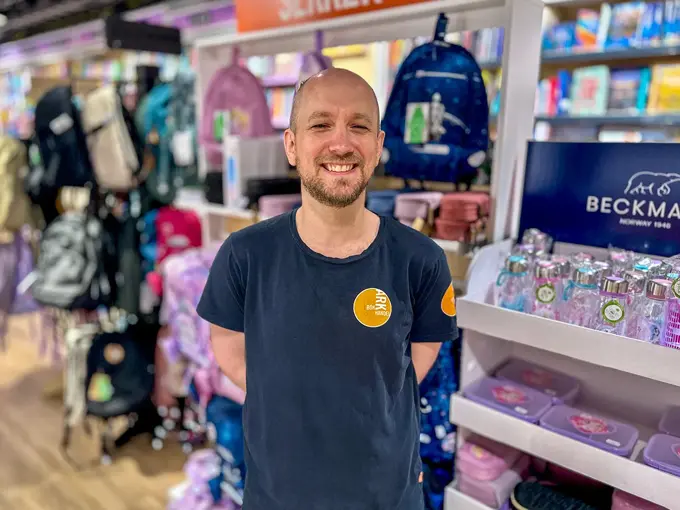 Ansatt fra Ark Bokhandel som smiler i butikken