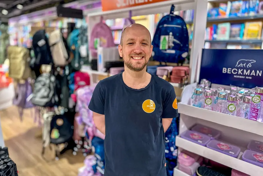 Ansatt fra Ark Bokhandel som smiler i butikken