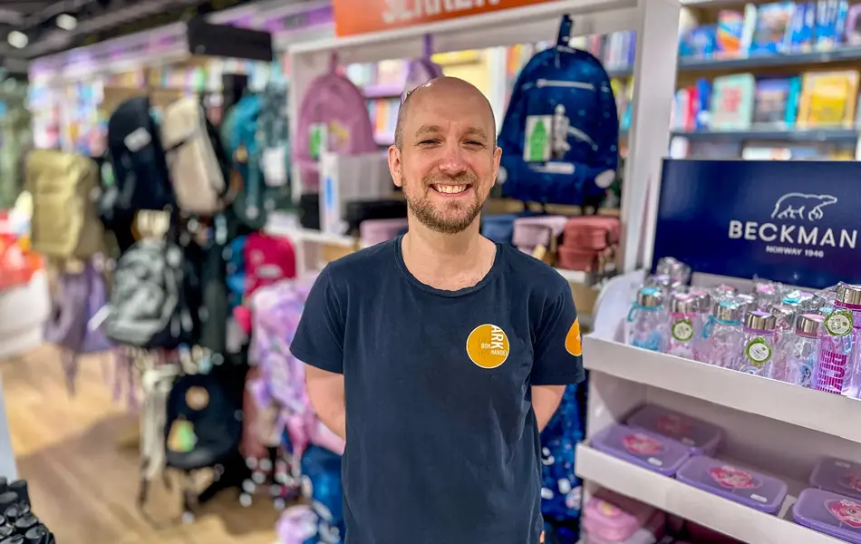 Ansatt fra Ark Bokhandel som smiler i butikken