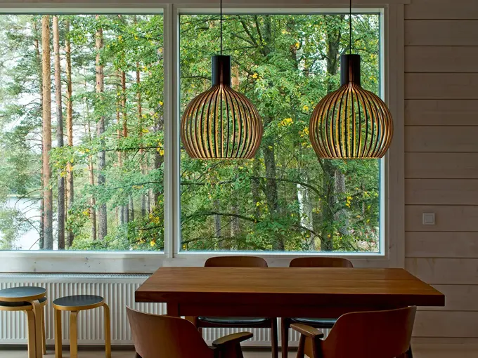 To taklamper i bjørkefiner henger over et spisebord.