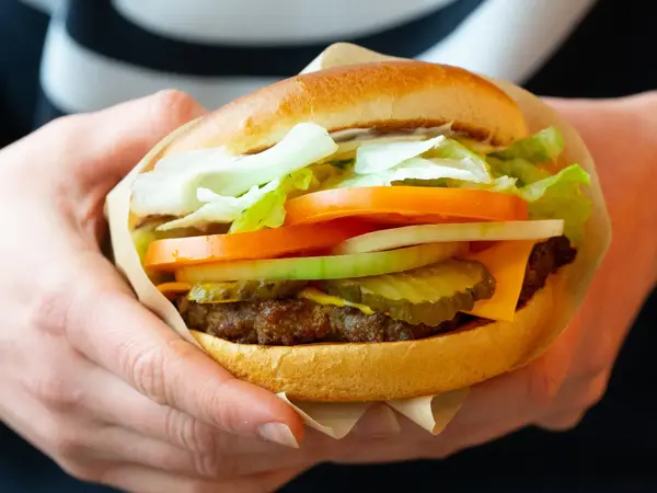 En hamburger i et hamburgerbrød med salat