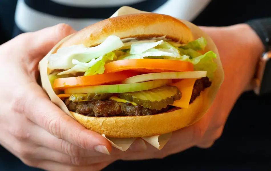 En hamburger i et hamburgerbrød med salat