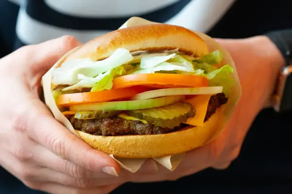En hamburger i et hamburgerbrød med salat
