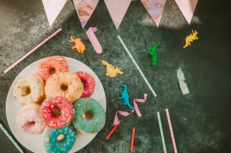kid party table setting with colorful doughnuts