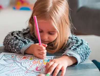 Family colouring books in their living room. They are having fun together.
